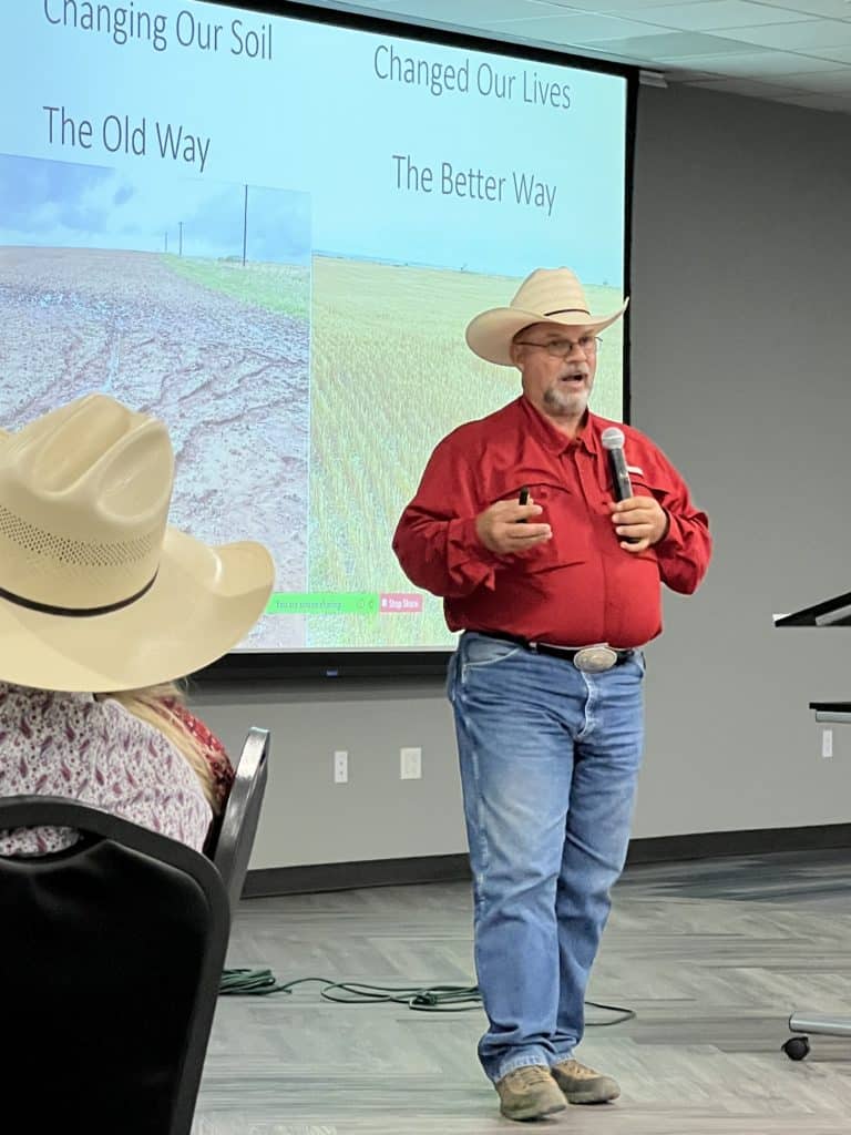 Oklahoma farmer Jimmy Emmons speaks into a microphone while presenting.