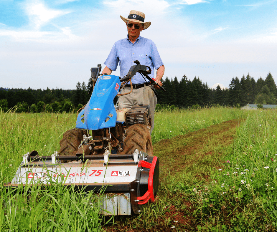 Man in field with flail mower