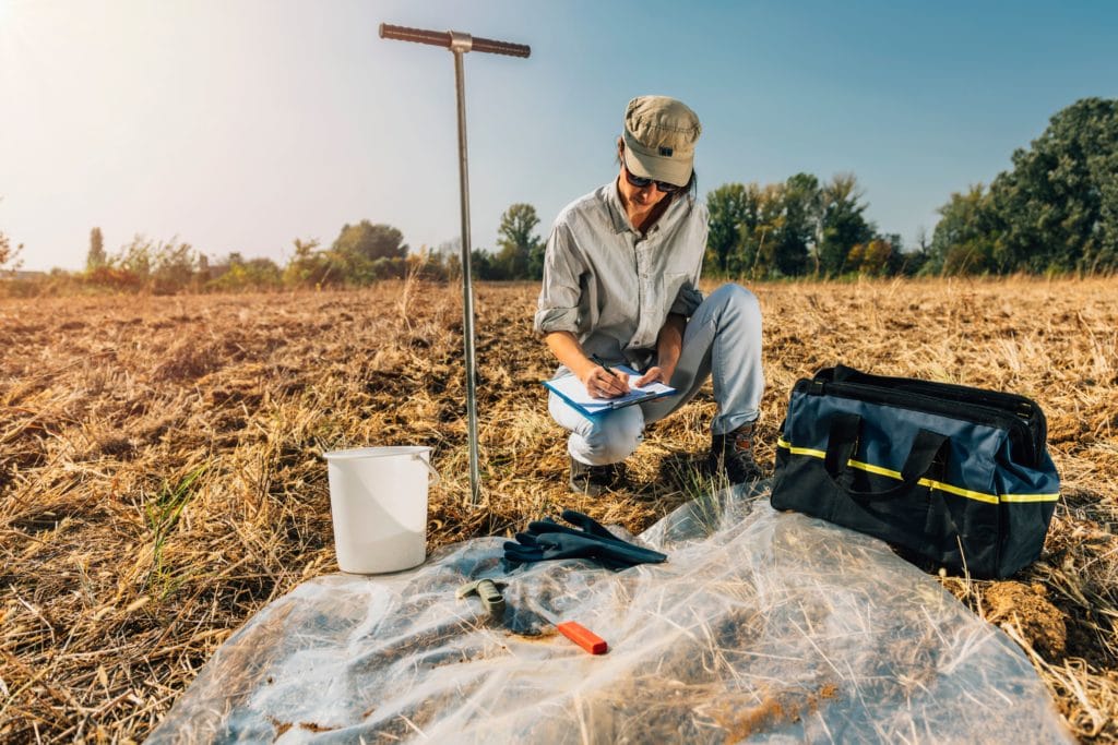 woman testing soil in field