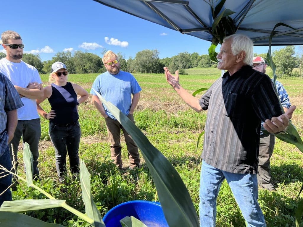 Gary Zimmer teaches a group outside in a field on his farm