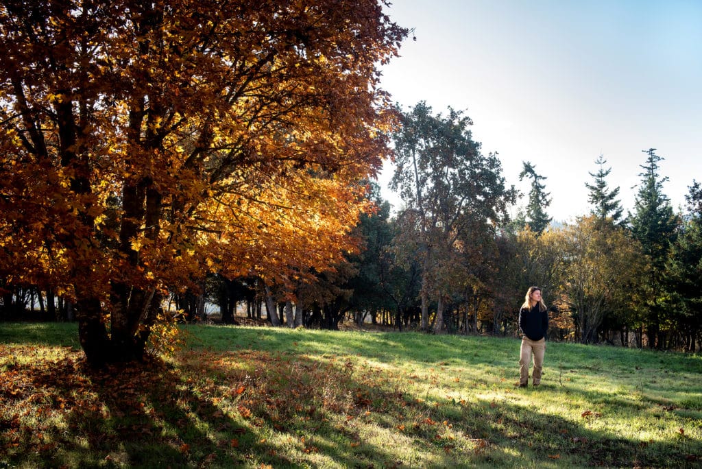 Mimi Casteel stands beside a tree at Hope Well Vineyard in Oregon