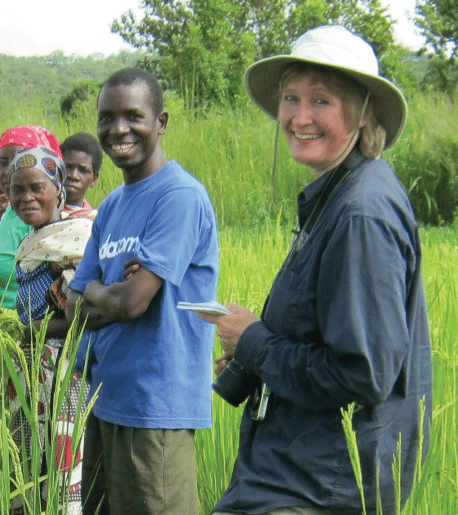 Dr. Erika Styger standing with farmers in the field