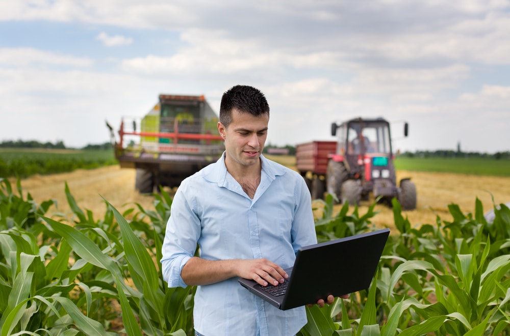 man on computer in field